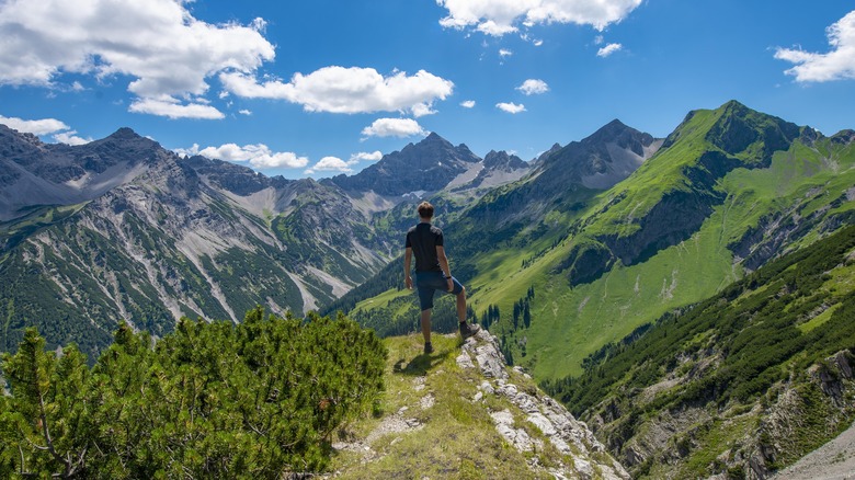 A hiker poses on Alpine mountaintop