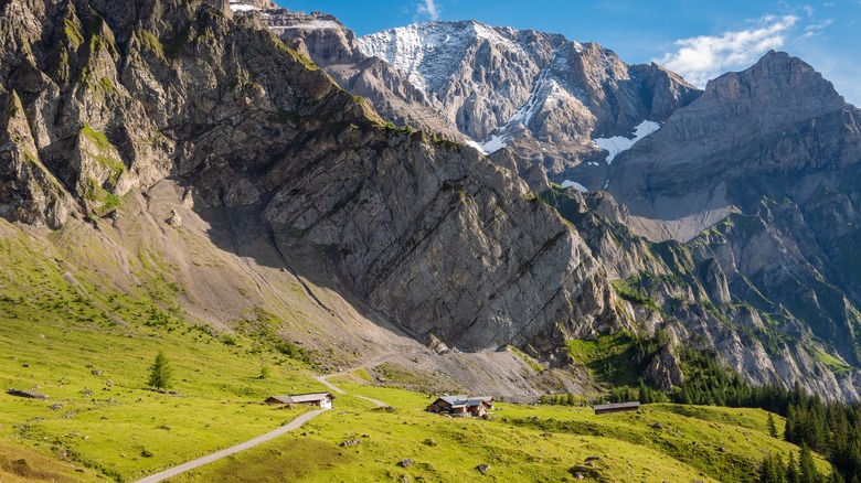 A house nestled beneath Alpine cliffs