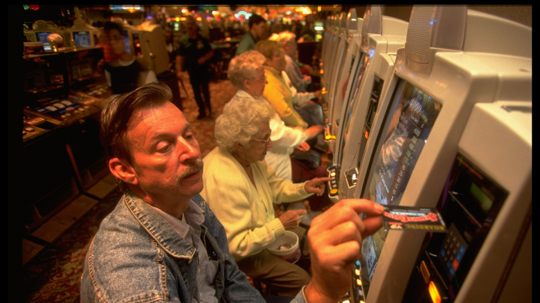 Man using casino card on a slot machine