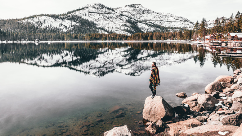 man looking out on lake tahoe in winter