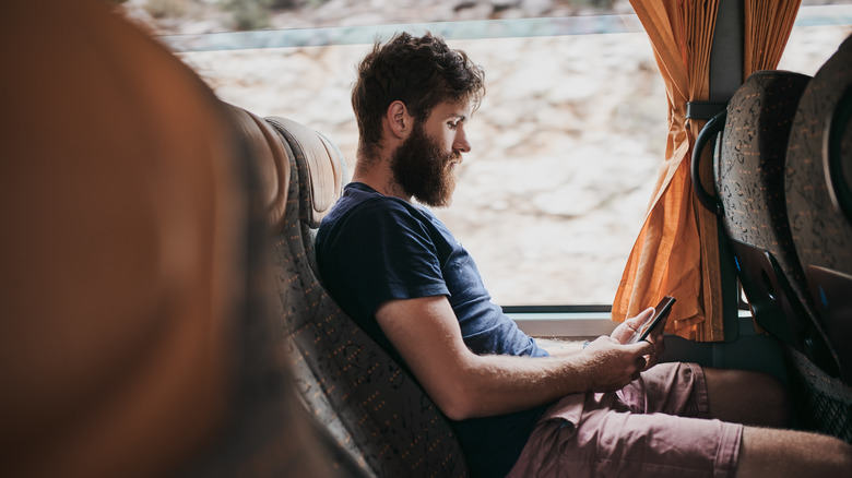 Man on bus with phone