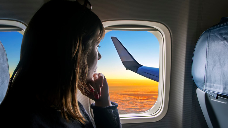 passenger looking out airplane window