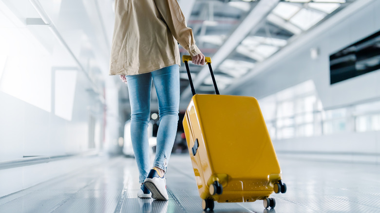 Woman walking with suitcase through airport