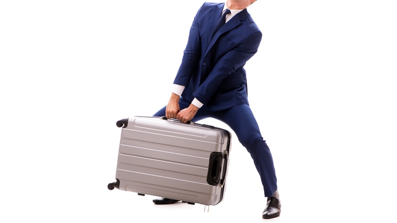 man carrying heavy suitcase