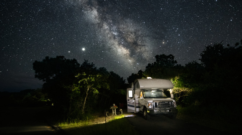 Parked RV under star-filled night sky