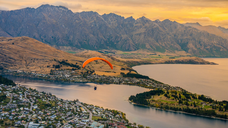 paraglider over water and mountains