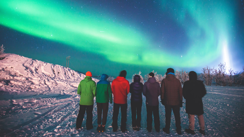 group of people northern lights