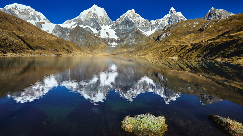 Siula Grande mountain range reflecting on glacial lake