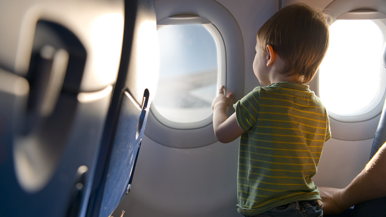 boy looking out plane window