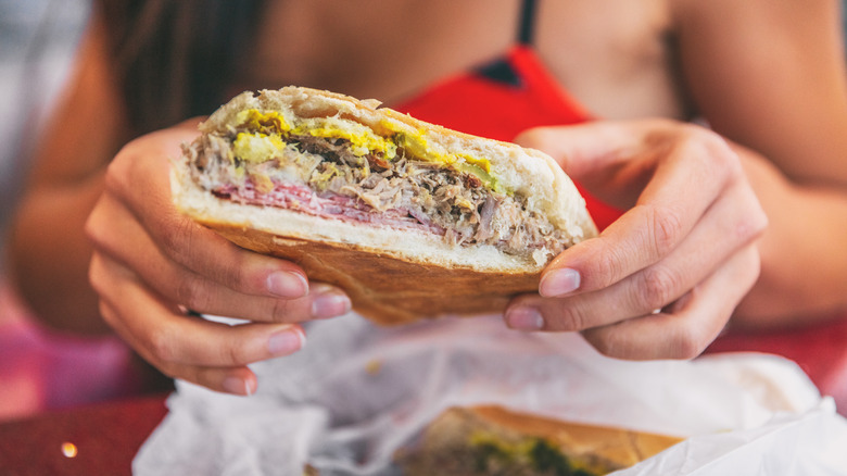 person holding a Cuban sandwich