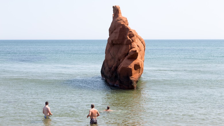 Men by ocean rock formation