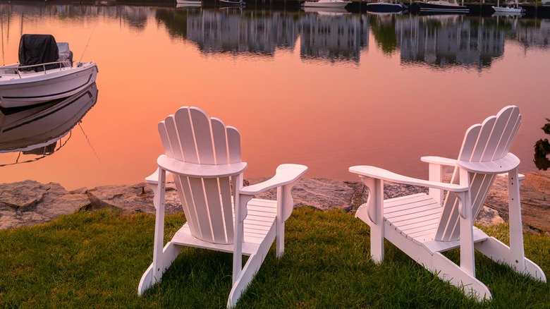 Adirondack chairs overlooking a river at sunset