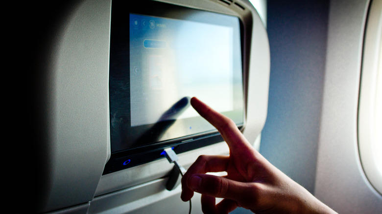 person picking movie on plane