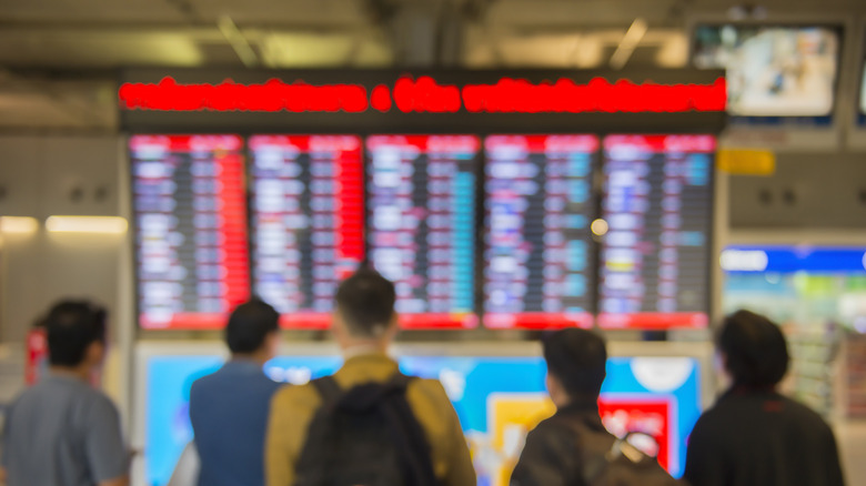 people at airport information board