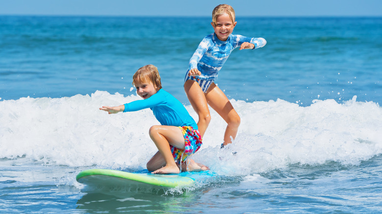 Excited kids on a surfboard