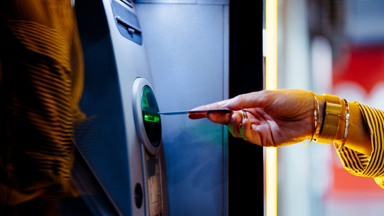 Person putting bank card into slot