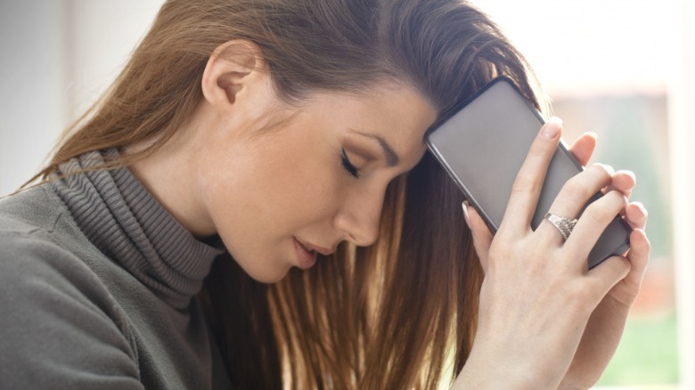 Frustrated woman holds phone