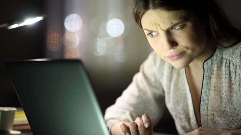 Woman gives laptop suspicious look