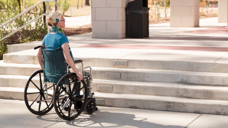 Woman in wheelchair, inaccessible stairs