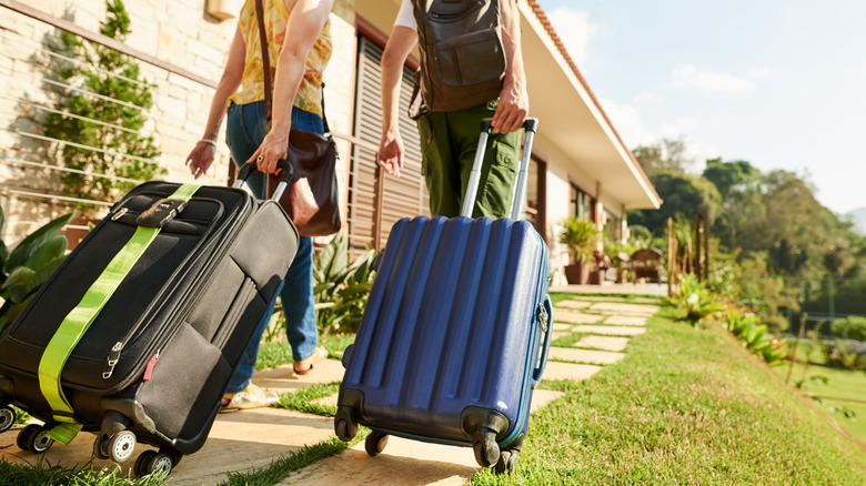 guest with suitcases leaving home