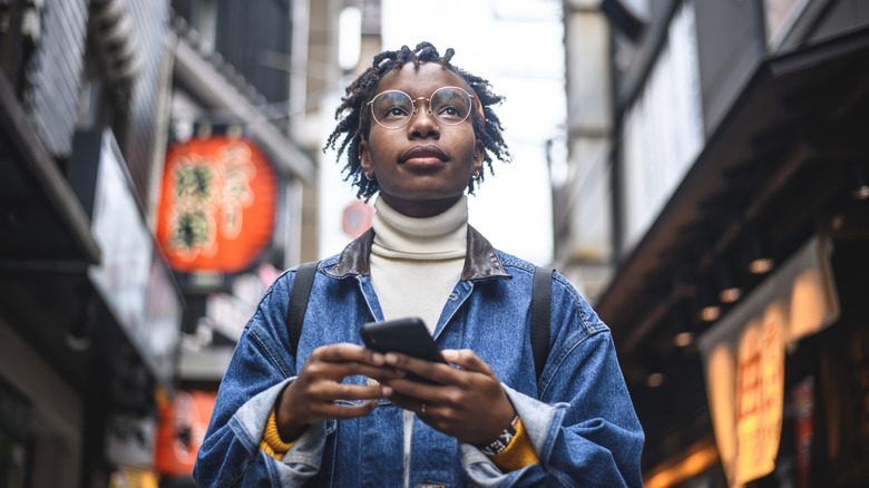 Young traveler holding cellphone