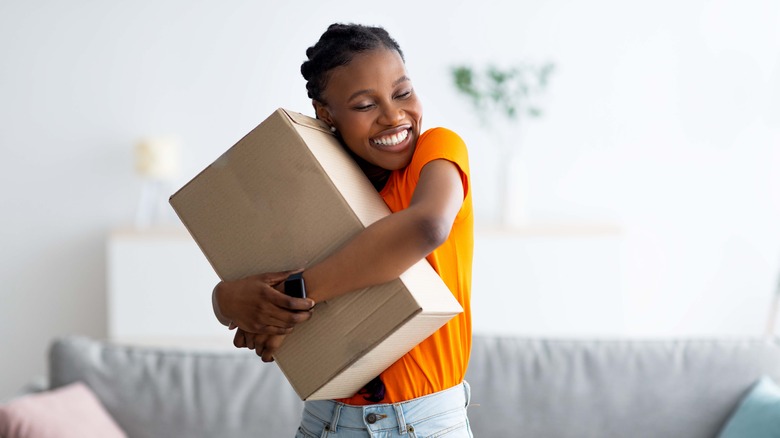 Happy woman hugging parcel
