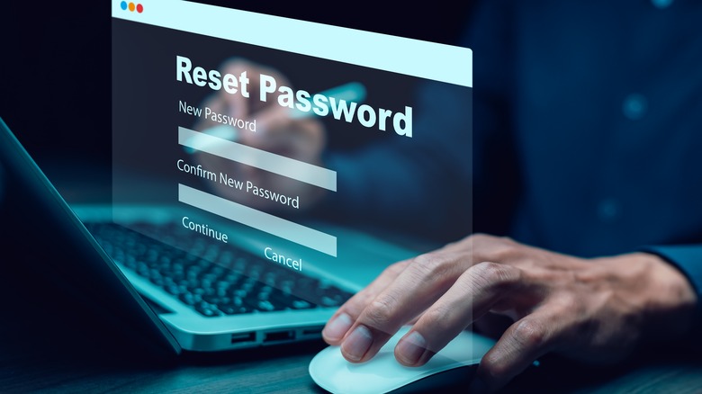 A hand utilizes a mouse and keyboard to reset a password