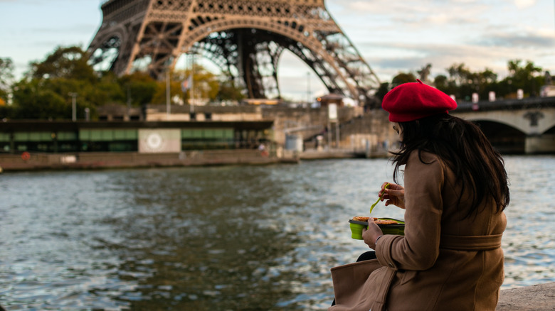 Woman eating by the Eiffel Tower