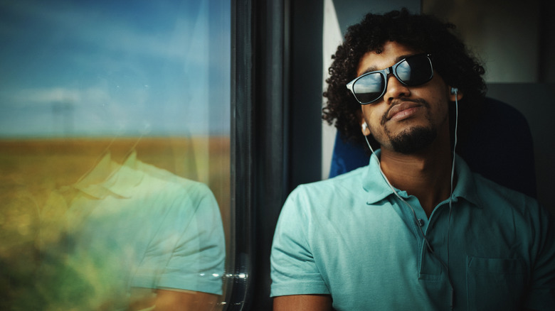 man with headphones on train