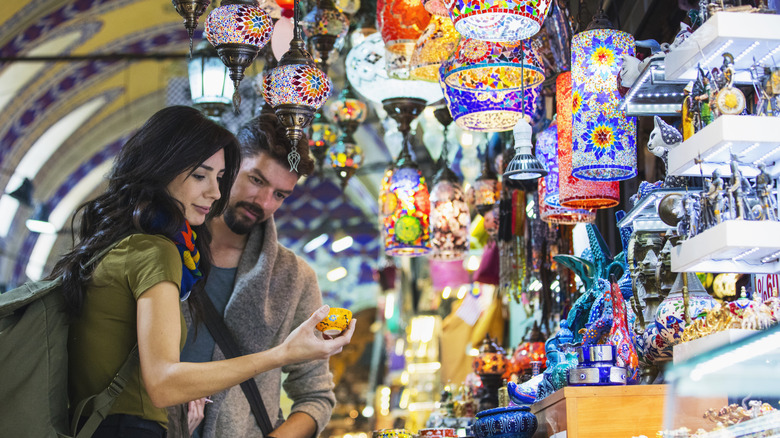 couple shopping for lamps in bazaar