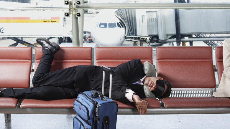 A person asleep in an airport.