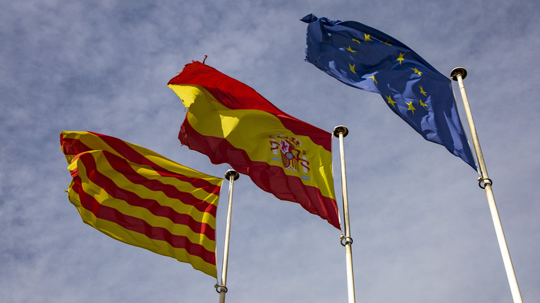 Three flags flying on flagpoles