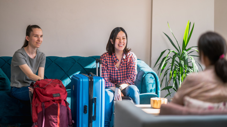 Women on couch with suitcases