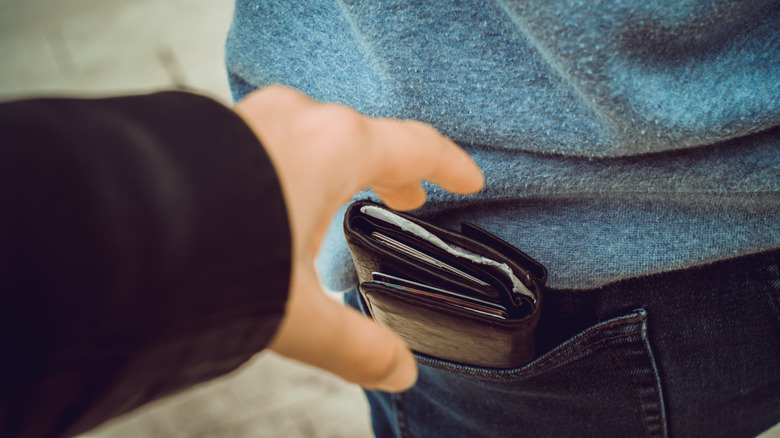hand grabbing wallet from pocket