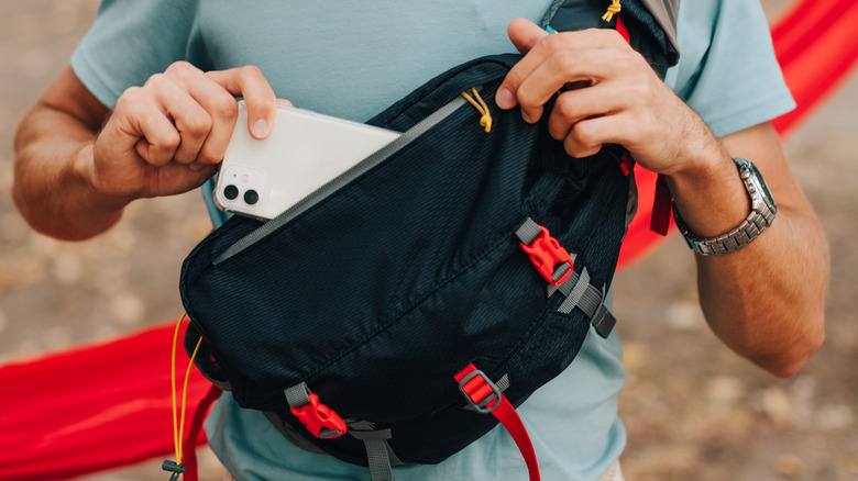 man putting phone into bag