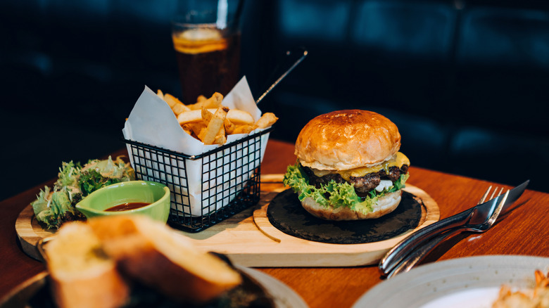 A burger and fries adorn a restaurant table