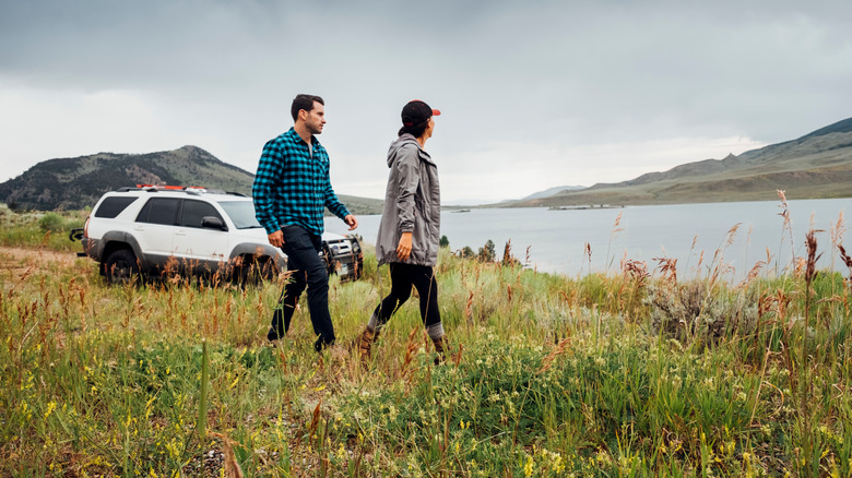 Couple walking in nature near car