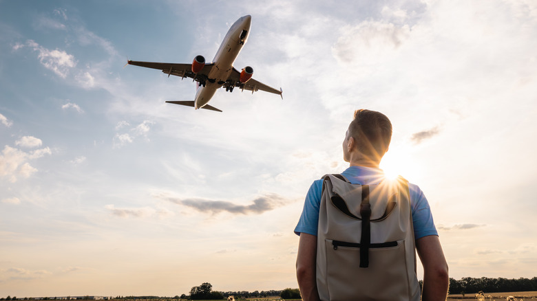 man looking up at plane