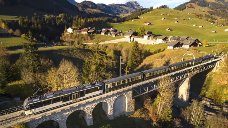 Switzerland's Cheese Train crosses a bridge near a small Alpine village