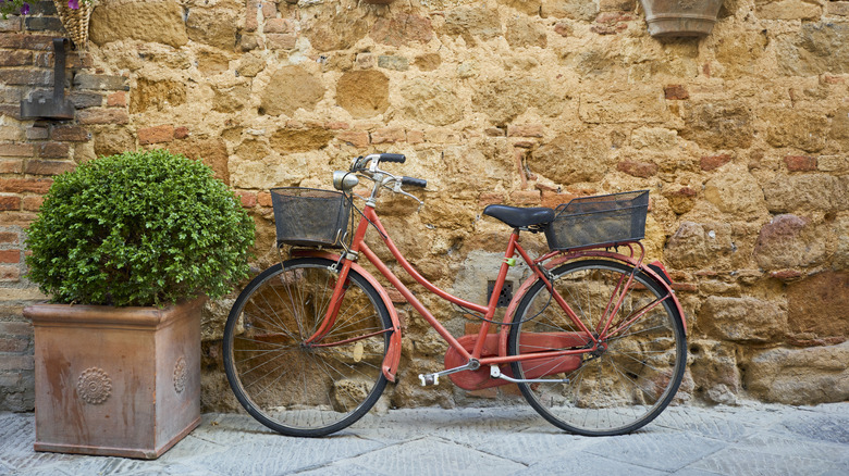 A bicycle rests against a stone wall