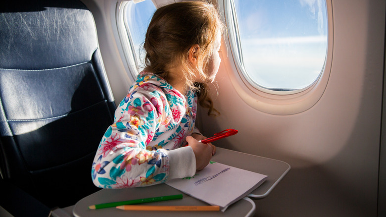 child drawing on plane