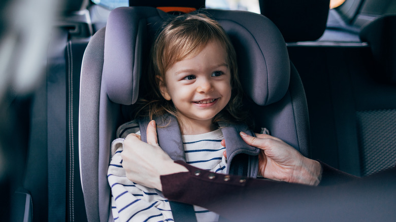 Parent buckling child to car seat
