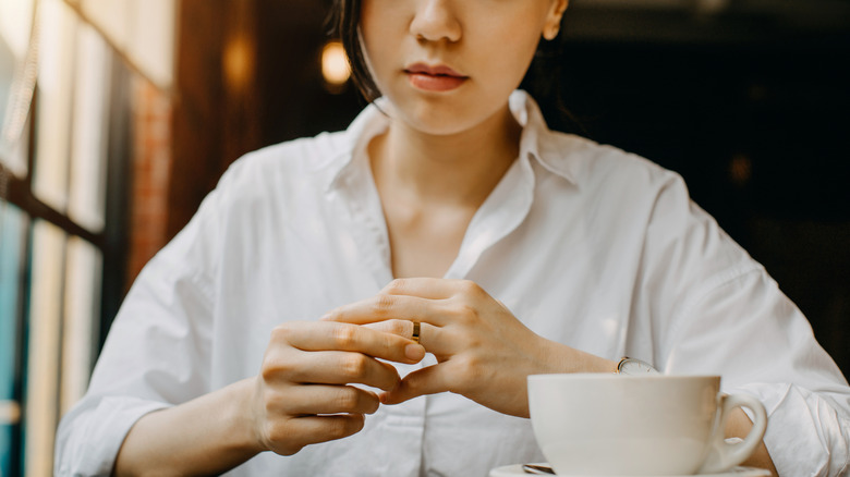 Woman nervously looking at wedding ring