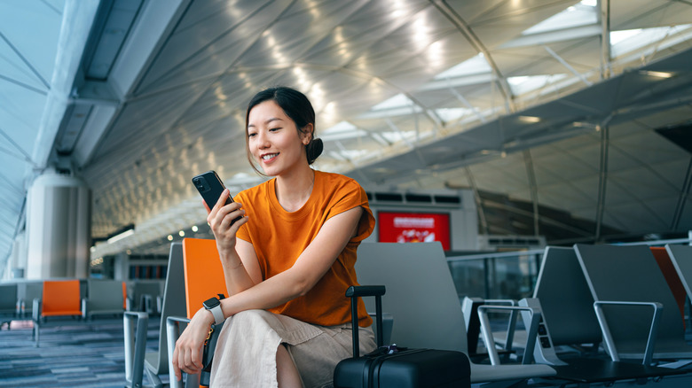 Woman looking at her phone in an airport