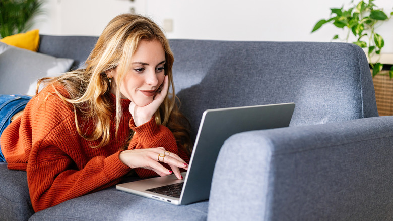 Woman looking at laptop on a sofa