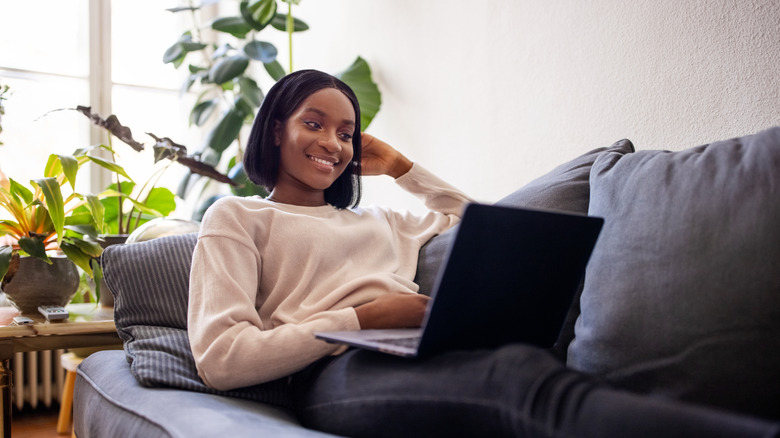 Woman looking at her laptop on a sofa