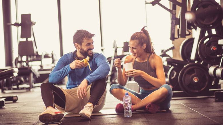 Man and woman sitting in gym