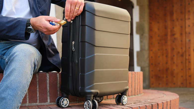 Man locking his suitcase