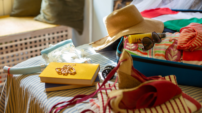 packing items for a vacation, on a bed