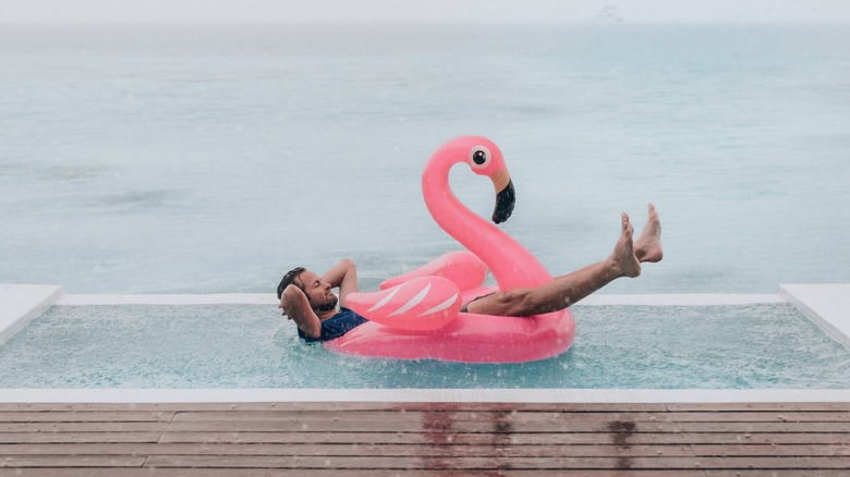 Traveler on a flamingo inflatable in the rain